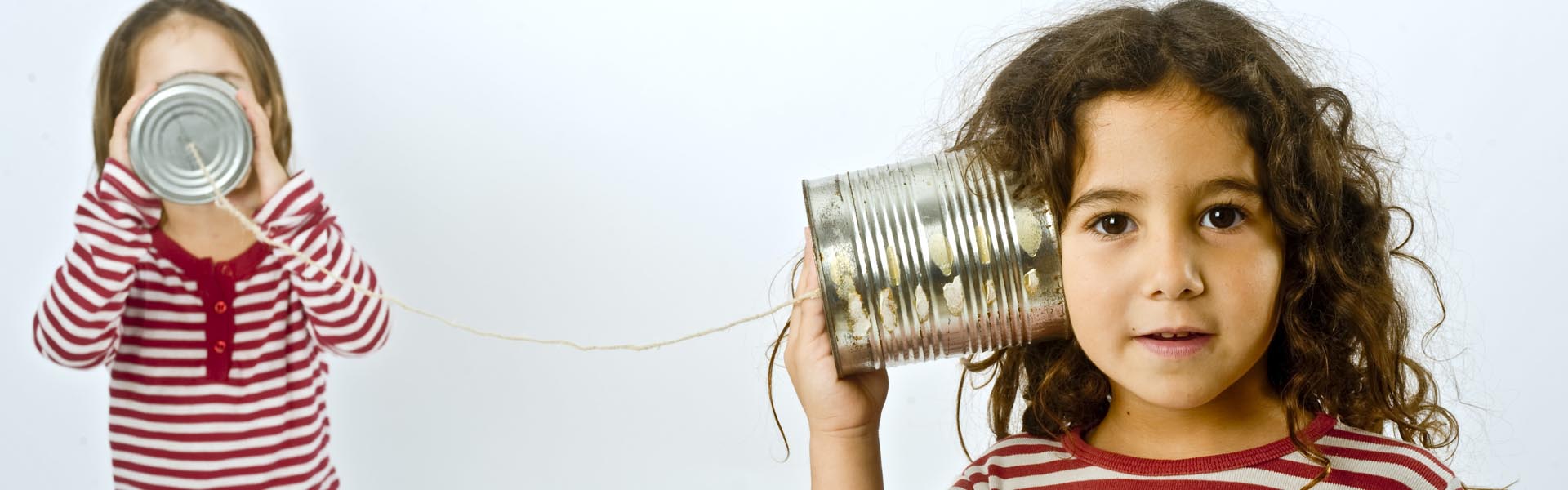 two girls talking on a tin phone